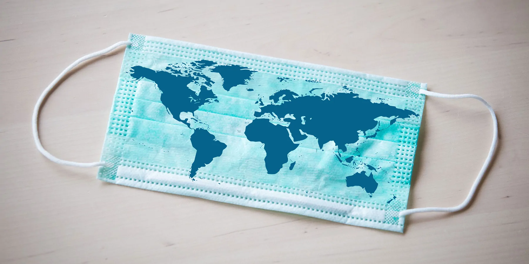 Experts Reach Consensus on How to End COVID-19 as a Public Health Threat A world map printed on a surgical mask