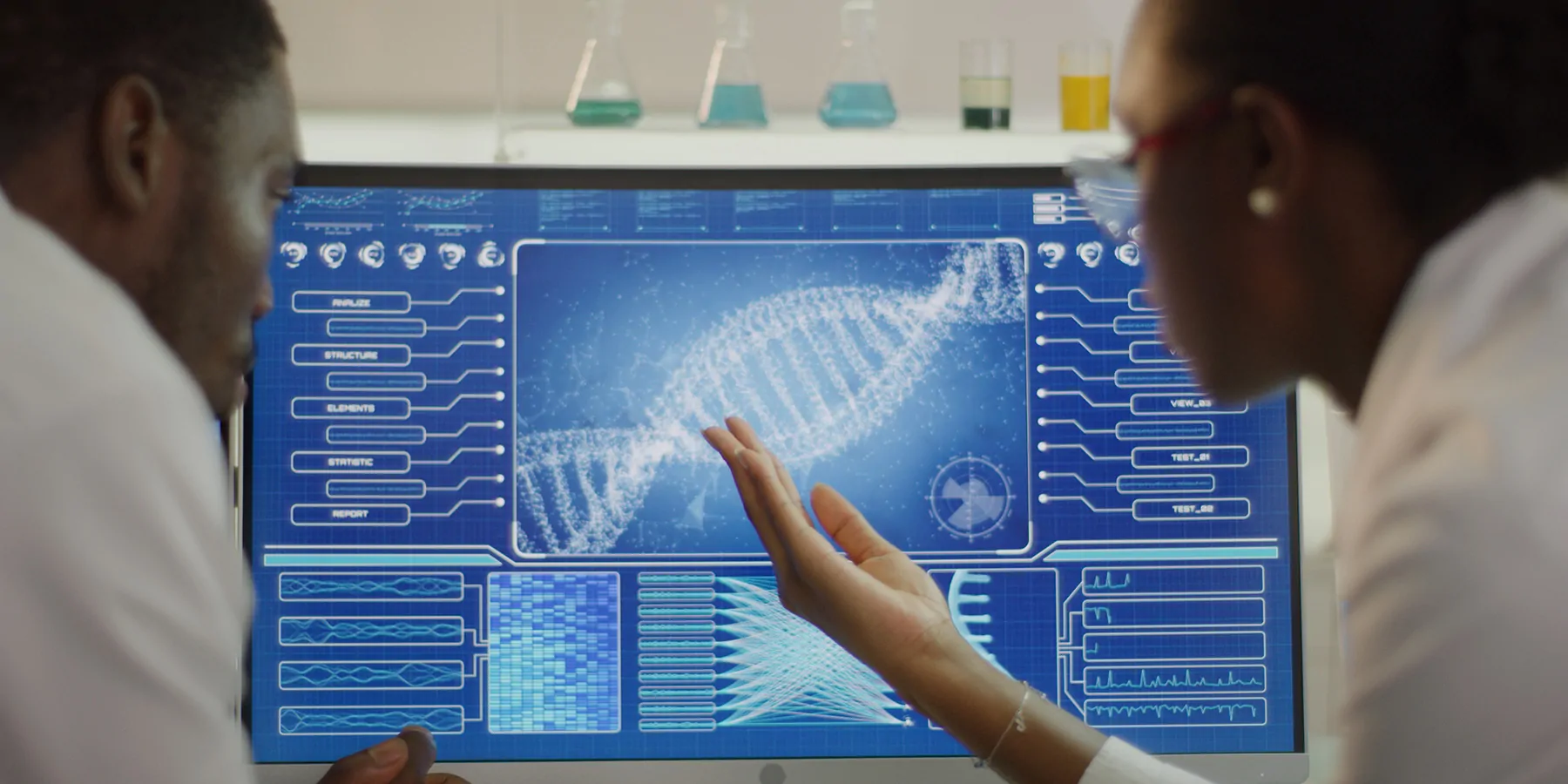 Two researchers looking at DNA on a computer screen