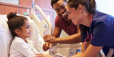 Pediatrician visiting patient in hospital bed