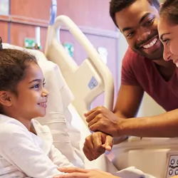 Pediatrician visiting patient in hospital bed