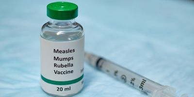MMR vaccine bottle next to a syringe 