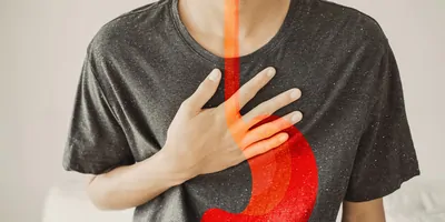 Person experiencing stomach distress with an overlay of the gastroesophageal junction in red