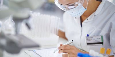 A young researcher recording her findings on a tablet in the lab