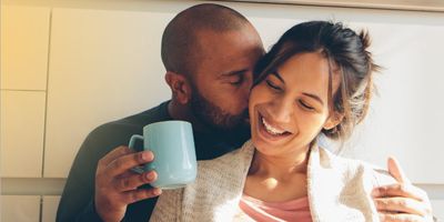 Couple cuddling in the morning with coffee