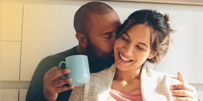 Couple cuddling in the morning with coffee