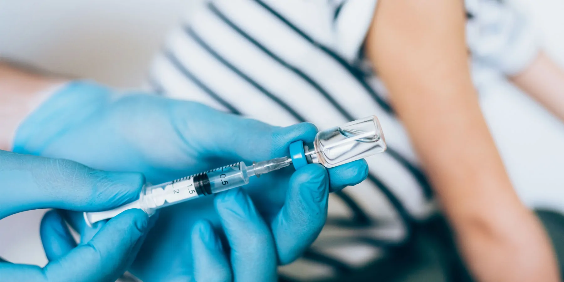 Health care professional administering a COVID-19 vaccine to a child