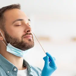Man getting a nasal swab done by a medical professional