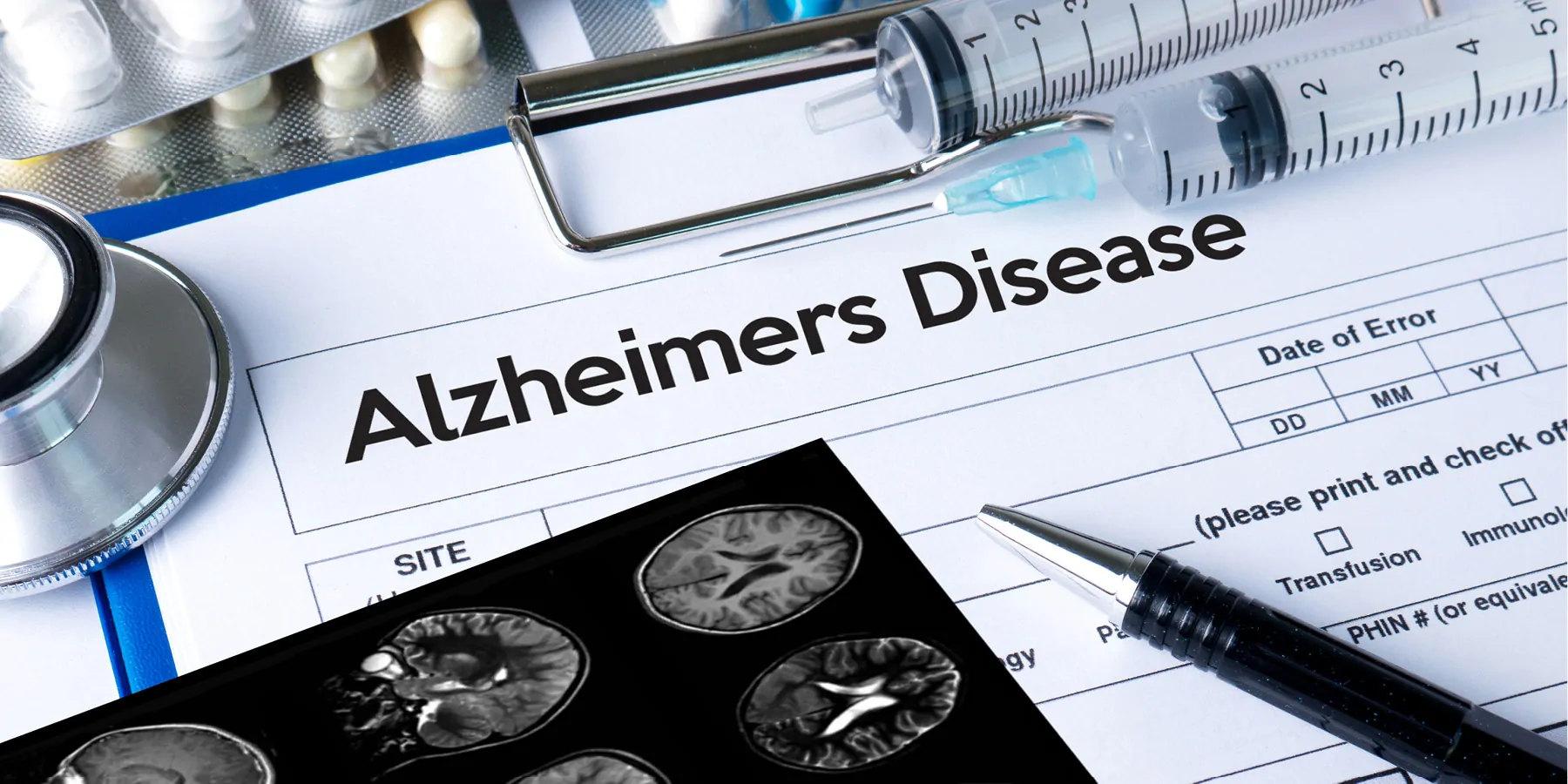 A clipboard with paper work for Alzheimers disease, brain images, a pen and some medication on it