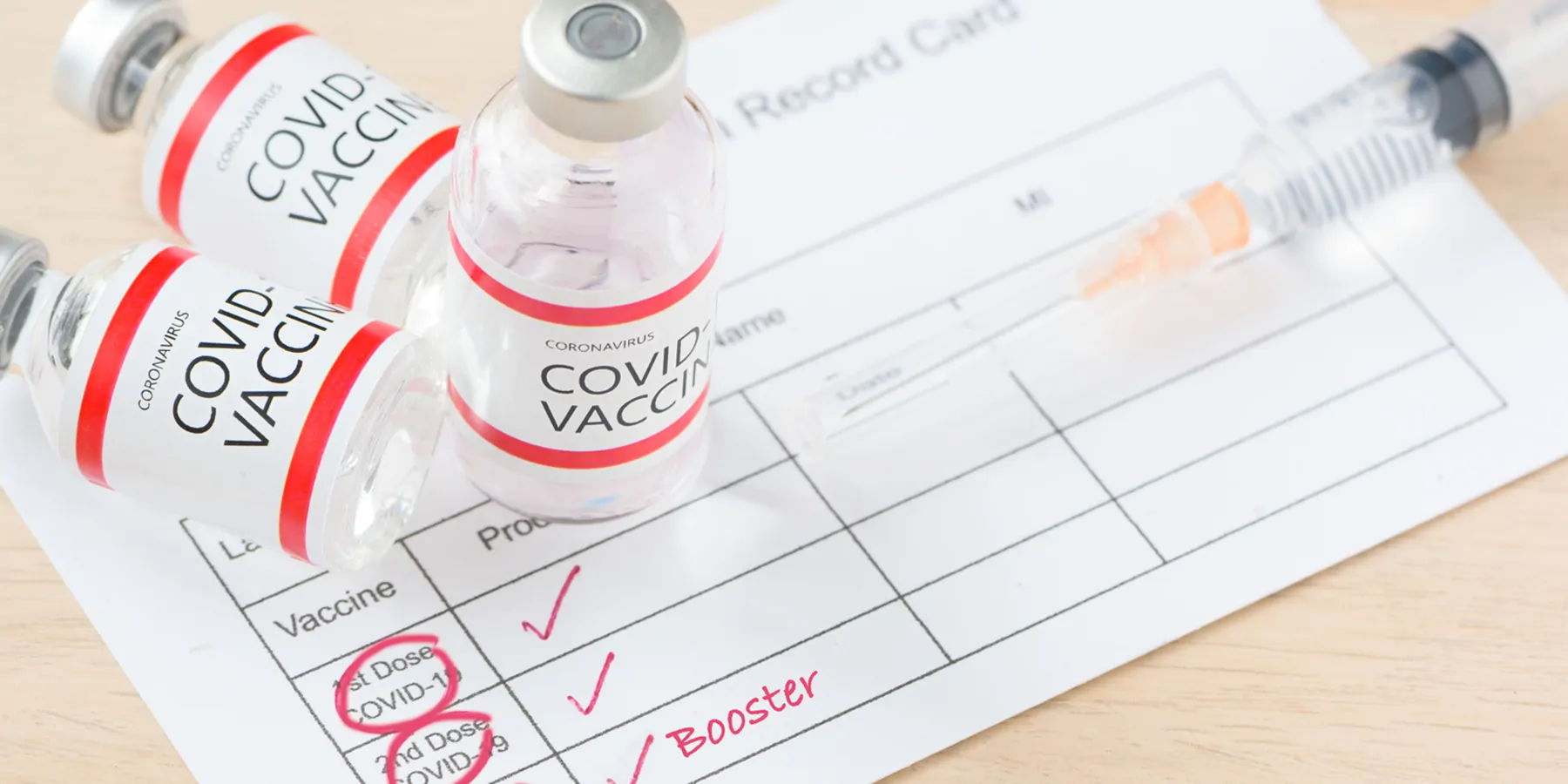 Three covid-19 vaccination bottles and a vaccination program indicating all three have been administered