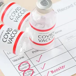 Three covid-19 vaccination bottles and a vaccination program indicating all three have been administered