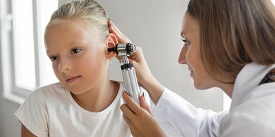 Child having her ears examined by a doctor