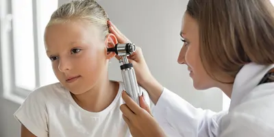 Child having her ears examined by a doctor