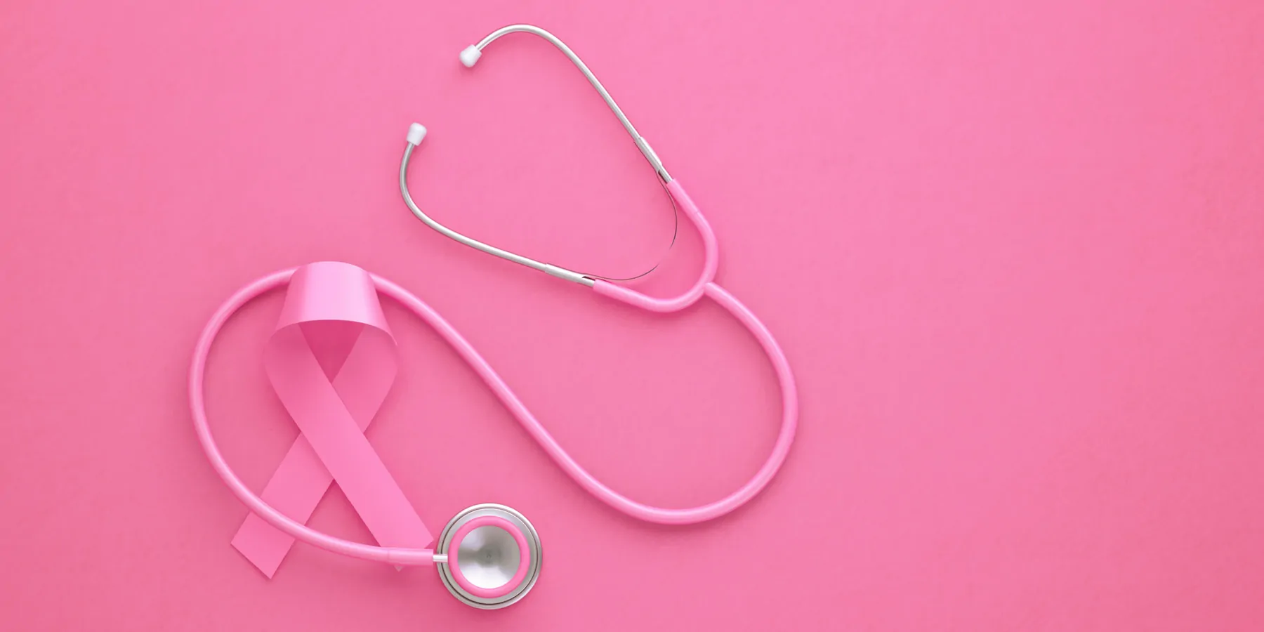 A pink ribbon and stethoscope on a pink background