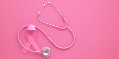 A pink ribbon and stethoscope on a pink background