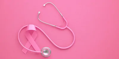 A pink ribbon and stethoscope on a pink background