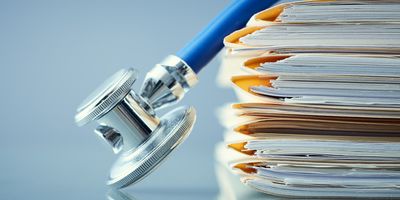 A stethoscope on a pile of paperwork