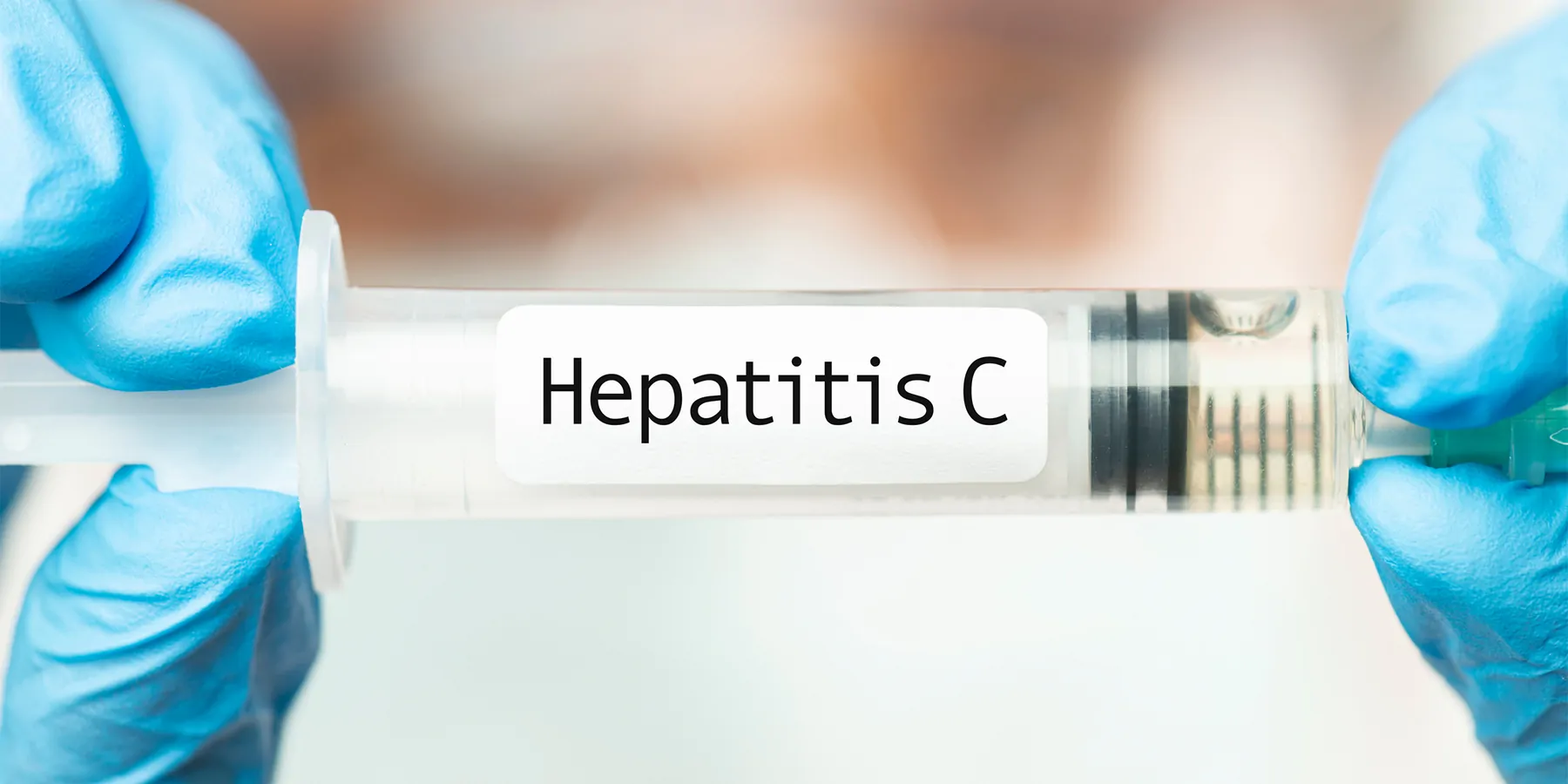 Medical professional holding a syring with Hepatitis C written on it