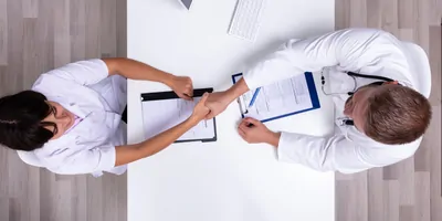 Two doctors shaking hands after reaching a deal