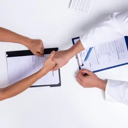Two doctors shaking hands after reaching a deal