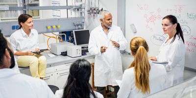 Photo of clinical trial professionals in conversation in a clinical lab site.