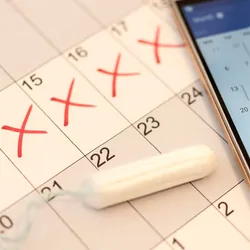 Photo of a calendar with red x’s marking menstrual cycle.