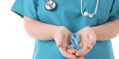 Clincians wearing scrubs and stethoscope holds a blue ribbon with prostate written on it.