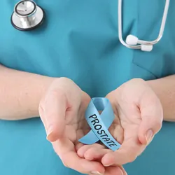 Clincians wearing scrubs and stethoscope holds a blue ribbon with prostate written on it.