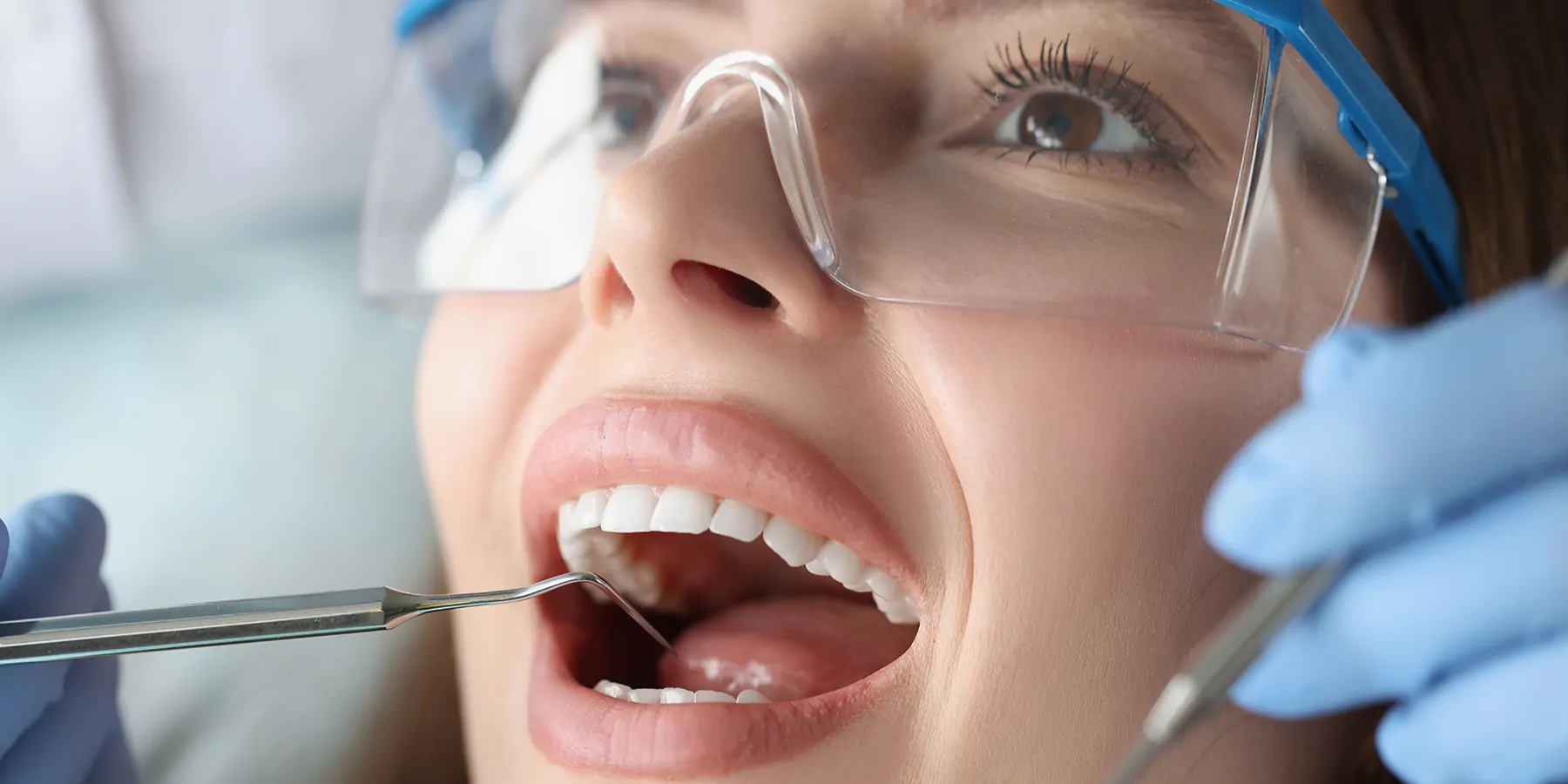 A dentist examines the oral cavity of a female patient.
