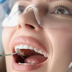 A dentist examines the oral cavity of a female patient.