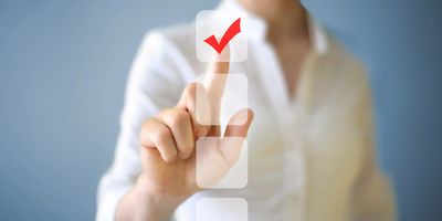 A silhouette of a woman checking off a box on a touch screen to symbolize survey on automated flow cytometry.
