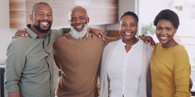 Cropped portrait of a happy family standing with their arms around each other in their home