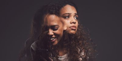 Studio shot of a young woman experiencing mental anguish and screaming against a black background