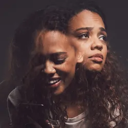 Studio shot of a young woman experiencing mental anguish and screaming against a black background
