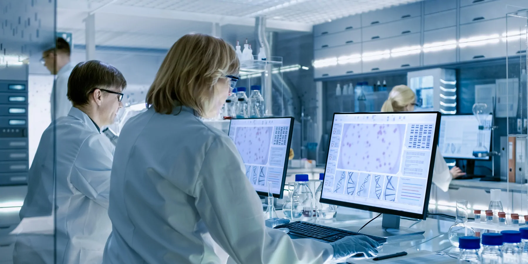 Female and male clinicians working on their computers in a large modern laboratory