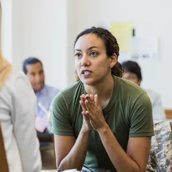 A female counselor listens to a stressed and anxious mid-adult female soldier.