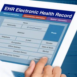Picture looking through the shoulder of a clinician working on electronic health record on a digital tablet