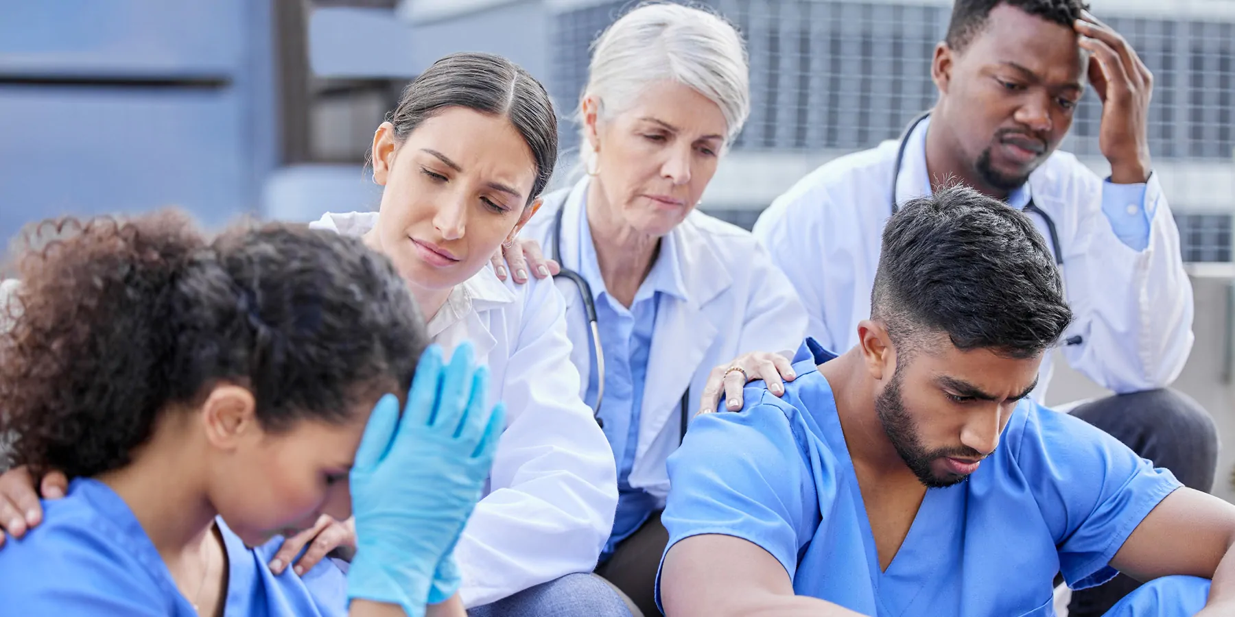 Study Finds High Rates of Burnout in Healthcare Professions Shot of a group of doctors looking sad against a city background