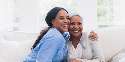 An elderly woman enjoys an embrace from her favorite home healthcare nurse.