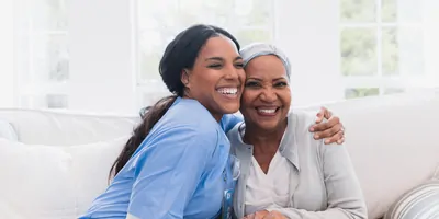 An elderly woman enjoys an embrace from her favorite home healthcare nurse.