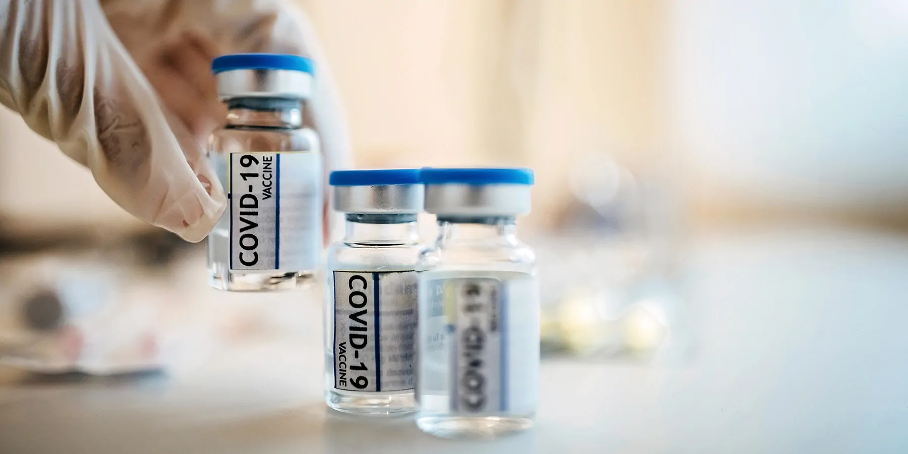 A clinician  lifts a Covid-19 vaccine vials
