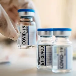 A clinician  lifts a Covid-19 vaccine vials
