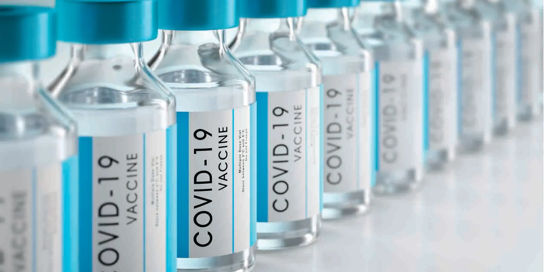 A row of COVID-19 vaccine vials on a white background.