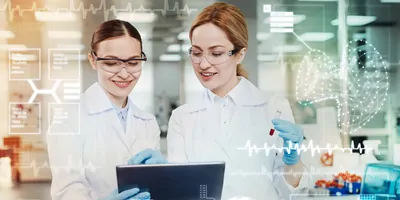 Clever enthusiastic positive doctors feeling glad while standing in their modern equipped laboratory and looking at the screen of a tablet