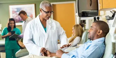 Senior phlebotomist checking on patient before taking blood sample