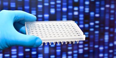 A gloved hand holds a microplate against a background of DNA bands on electrophoresis gel glowing in blue.