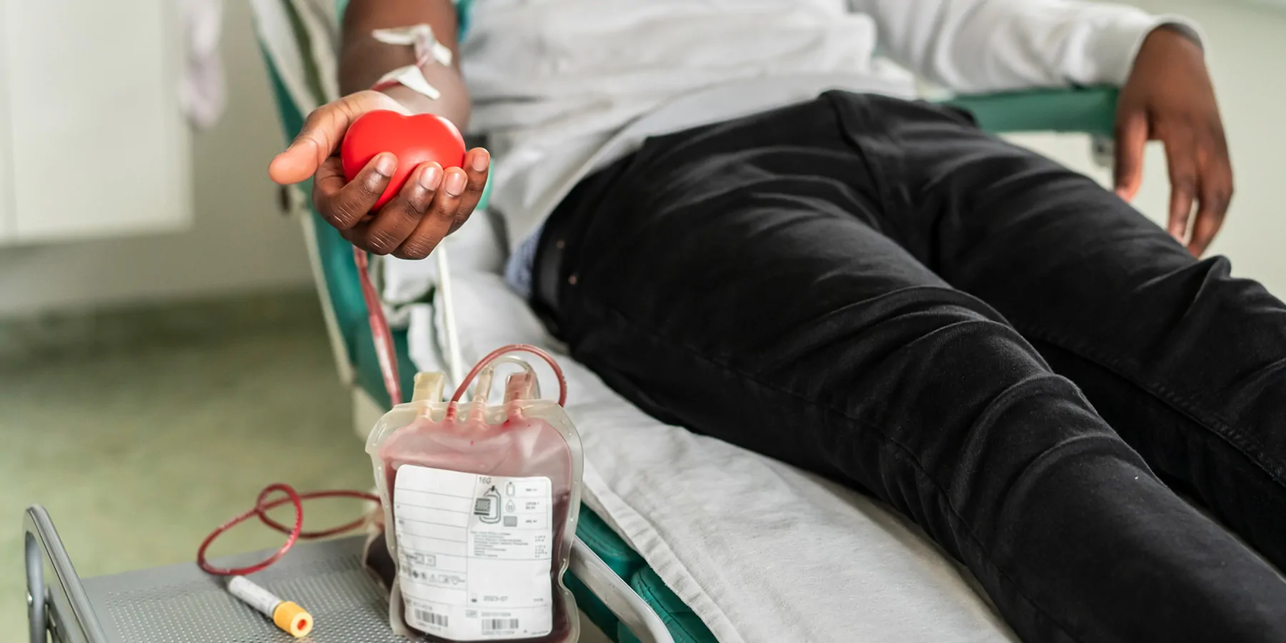 The hand of a blood donor squeezing a medical rubber heart