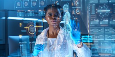 A young female clinician works on a graphic display with several health care-related icons in a modern laboratory.