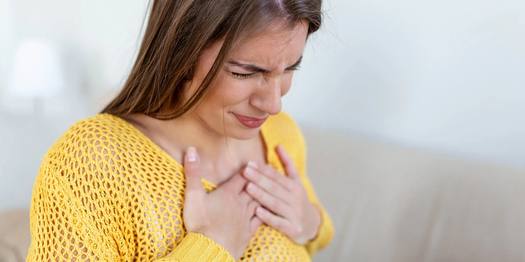 Young woman having acute chest pain or possibly a heart attack.