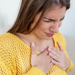 Young woman having acute chest pain or possibly a heart attack.