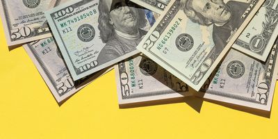 Dollar bills laid on a yellow background